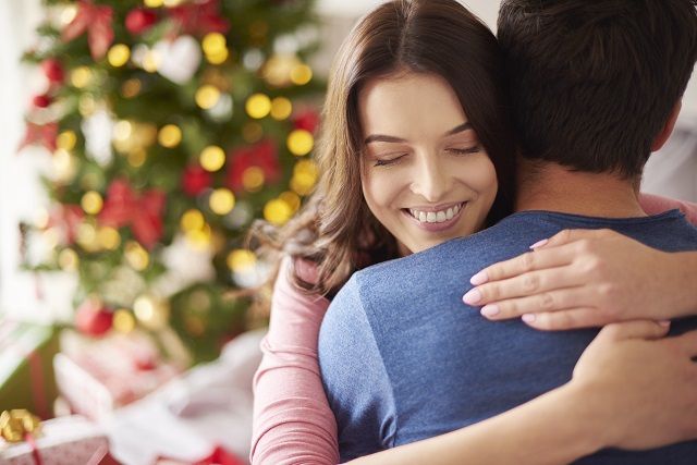 Оригінальні привітання зі Старим Новим роком Smiling woman embracing her boyfriend in Christmas