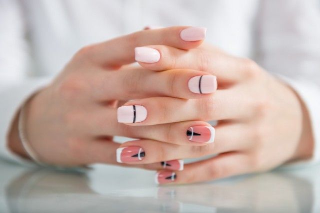 Beautiful female hands with a fashionable manicure. Geometric design of nails. Photo closeup