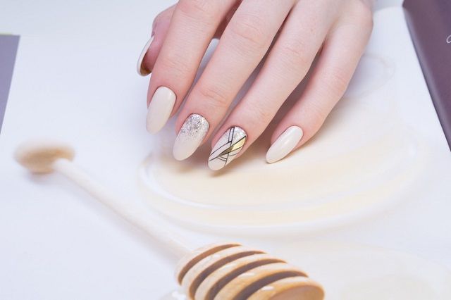 Attractive manicure on women's hands. Natural finger nails with stylish nail art.