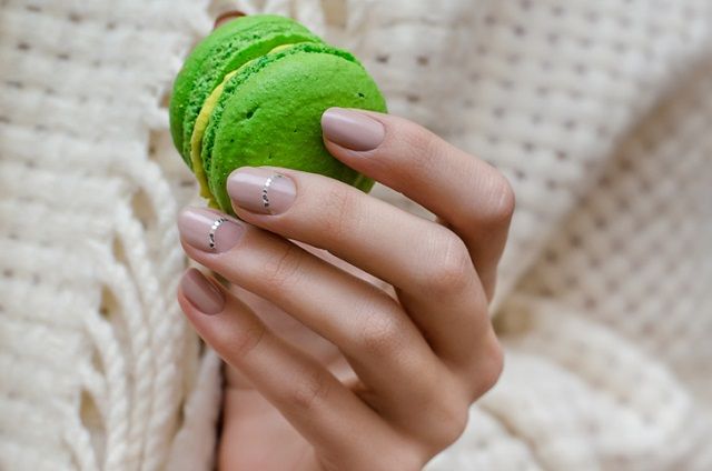 Female hands with pink nail design.