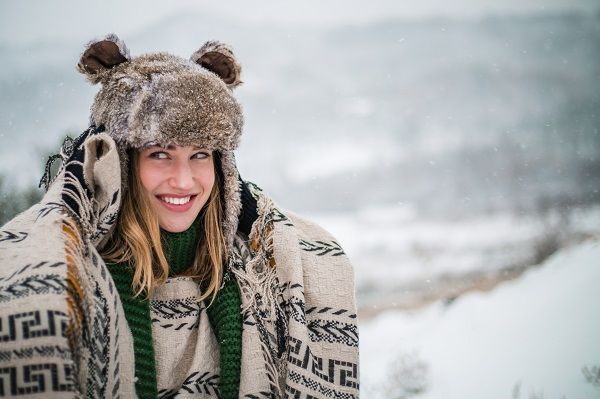 Beautiful woman with fur hat and scarf on snowy day