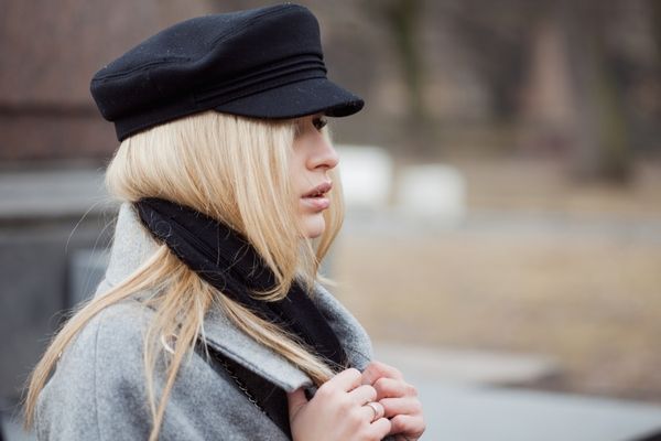 Young, hip and attractive blonde walking around the city, girl in a stylish hat and a gray coat