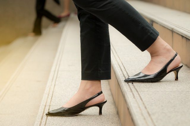 Women wearing high heels, legs are moving down staircases.