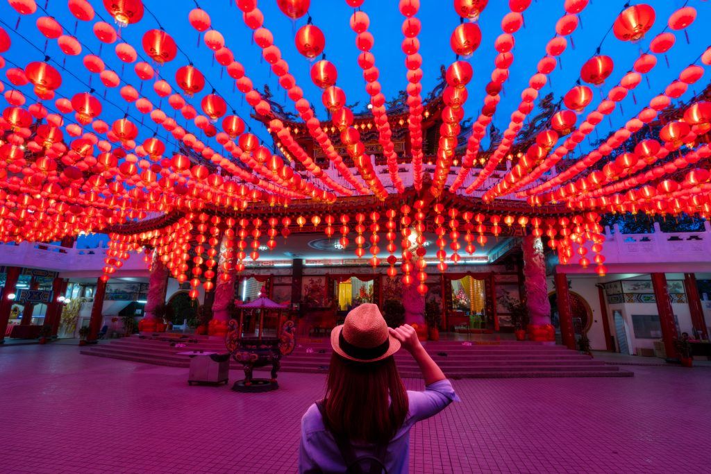 Когда китайский Новый год 2020 по восточному календарю Young woman traveler traveling and looking red lanterns decorations in chinese temple