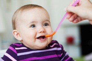 Baby Sitting in Chair Being Fed --- Image by © Emely/cultura/Corbis