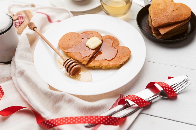 Лучшие романтические завтраки и ужины ко Дню Святого Валентина heart shaped pancakes on a light background. the concept of a festive breakfast for Valentine's Day or a pleasant surprise for a loved one