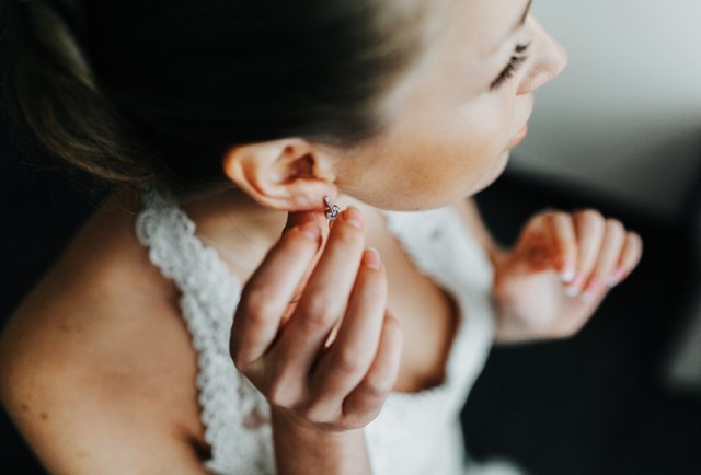 Проколювання вух: поради і протипоказання bride herself puts her earrings on the ears