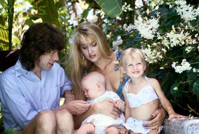 Знамениті багатодітні татусі ca. 1985, Barbados --- British singer-songwriter, leader of the Rolling Stones Mick Jagger, with his wife American model Jerry Hall, and their children Elizabeth Scarlett and James Leroy Jagger. --- Image by © Norman Parkinson/Sygma/Corbis