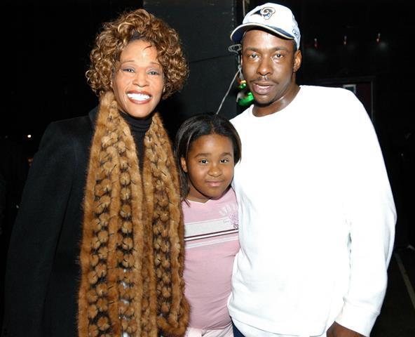 Умерла единственная дочь Уитни Хьюстон Whitney Houston and Bobby Brown watch from the side of the stage as John P. Kee performs at the Praise 97.5 "Praise Power" concert.